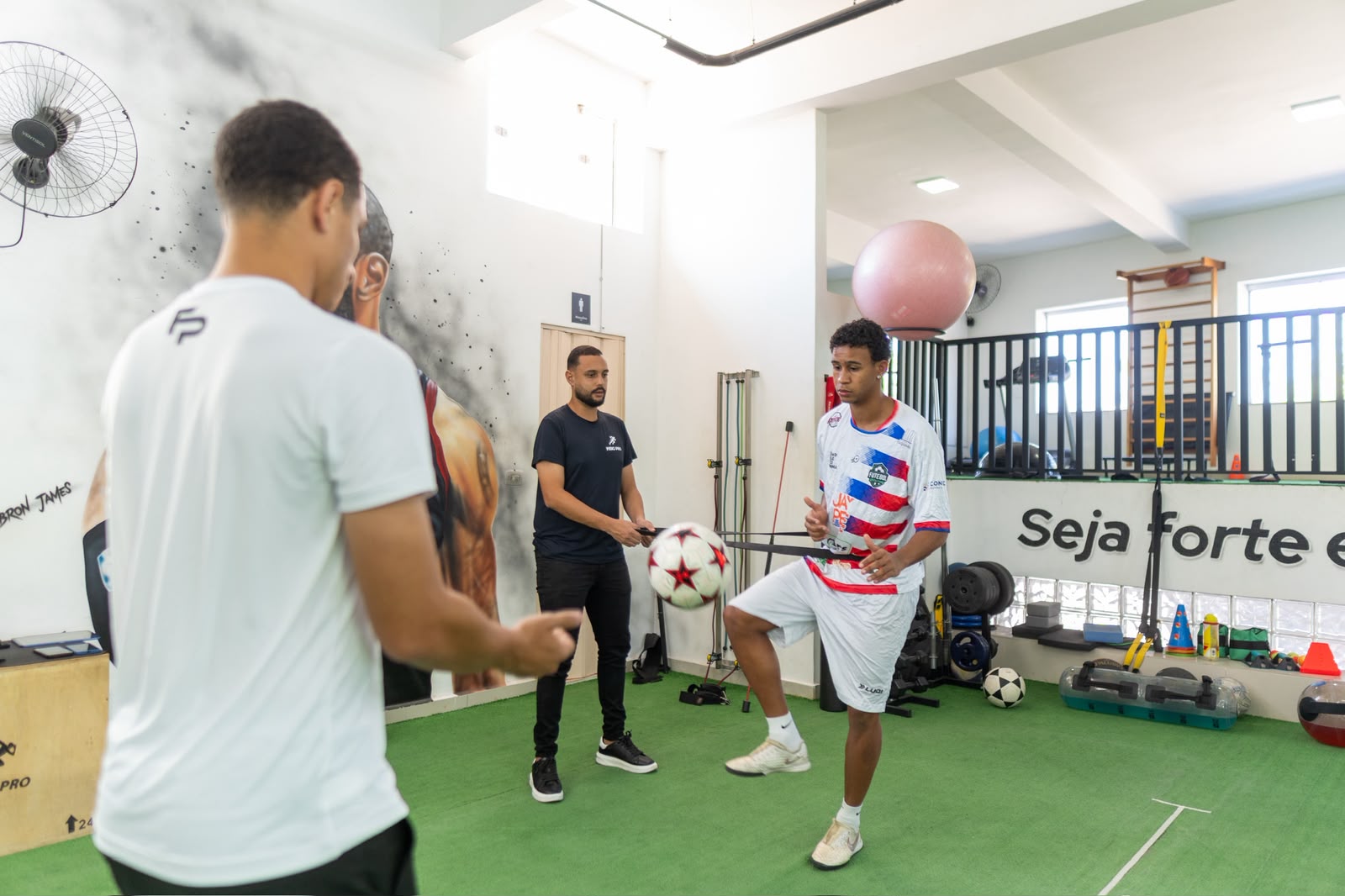 Atleta realizando teste funcional acompanhado por fisioterapeutas